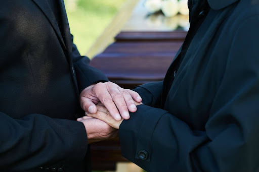 two people comforting each other during a funeral