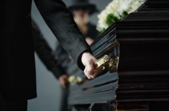 people carrying a coffin at a funeral