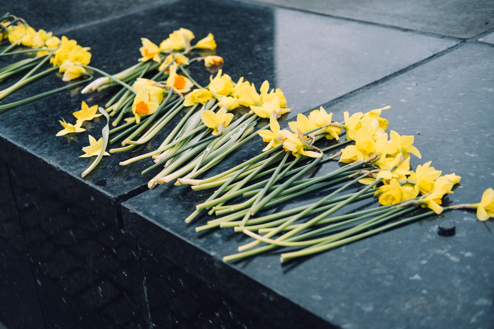 a stack of yellow flowers placed on top of a stone slab