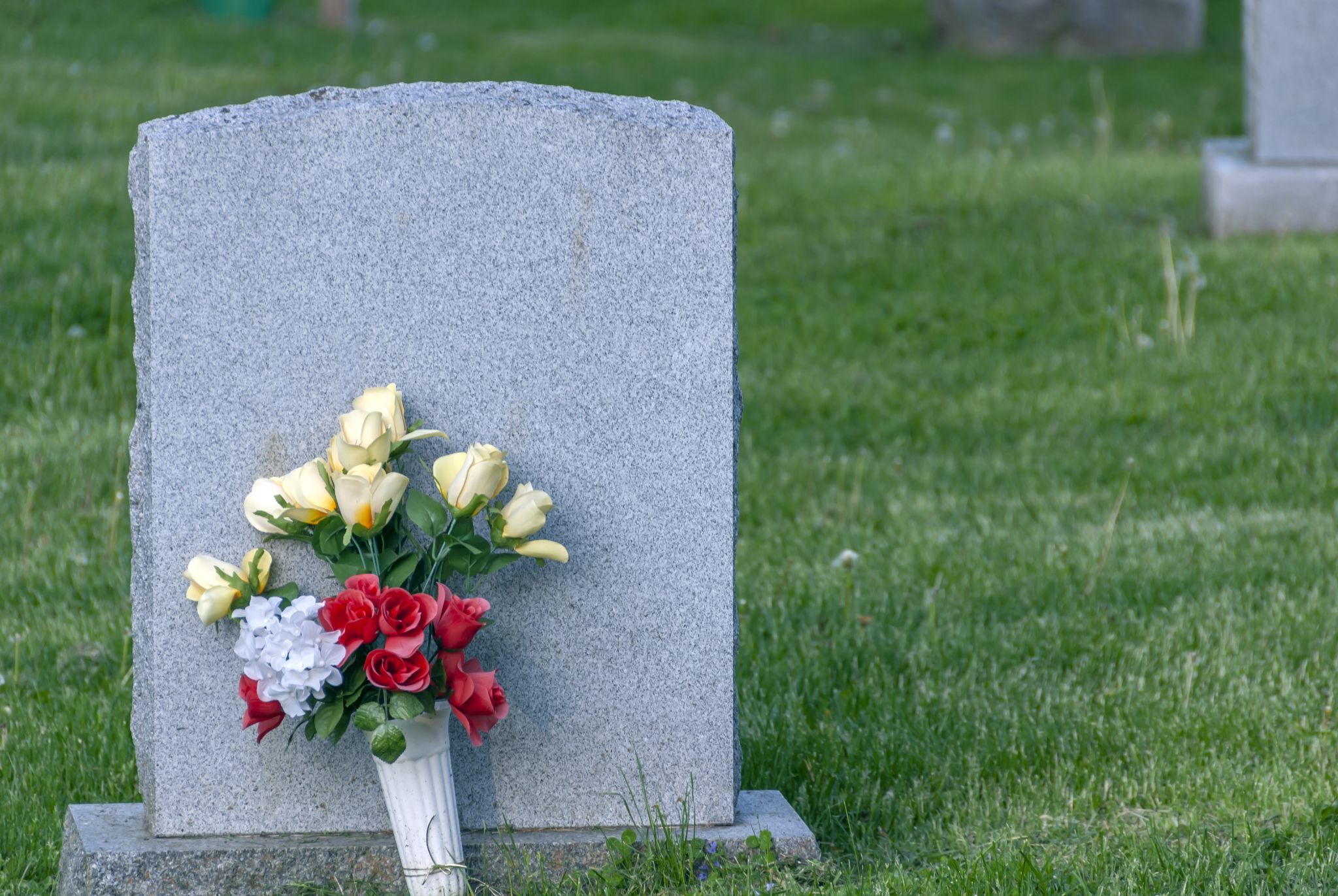 a bouquet of flowers put against on a grave stone